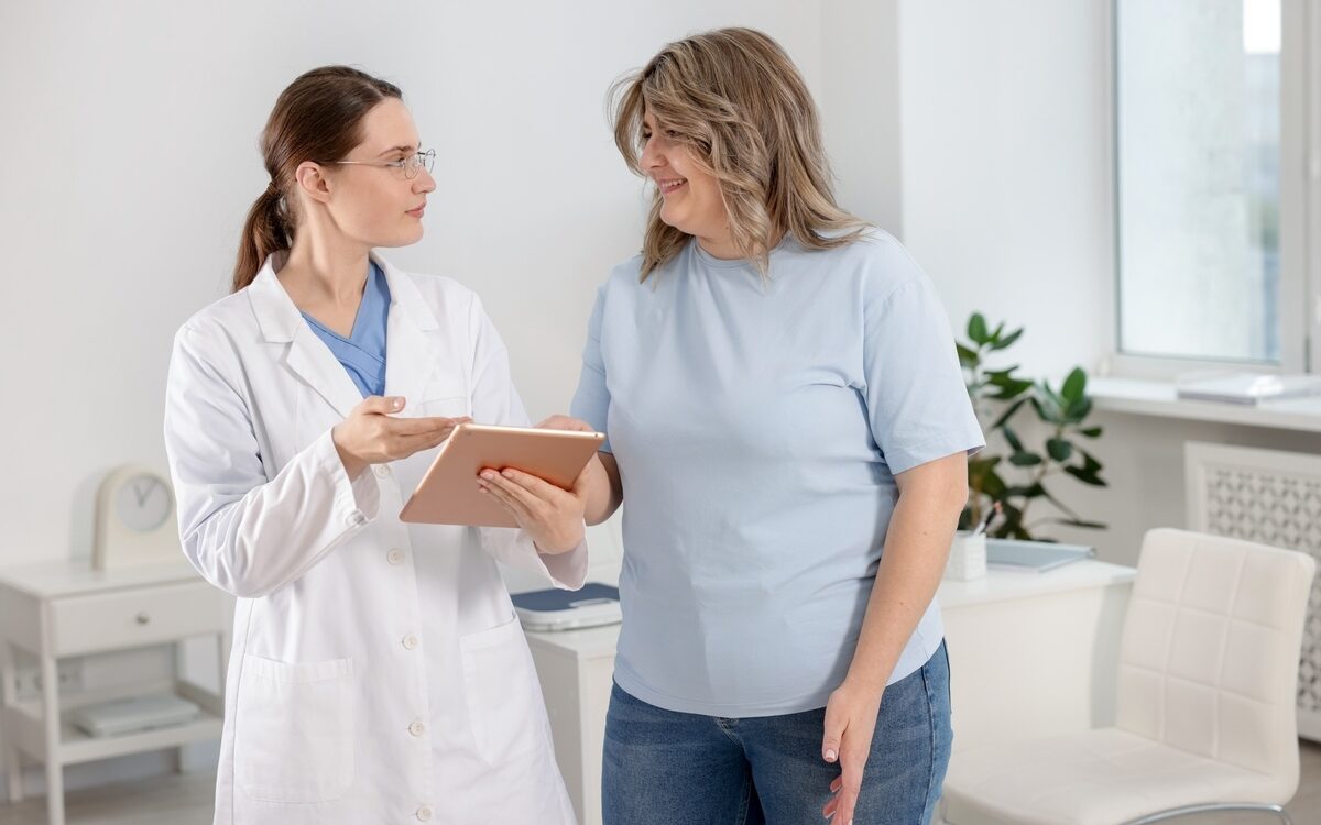 Healthcare provider reviewing a tablet with a woman during her first medical weight loss appointment