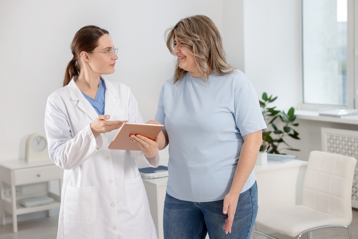 Healthcare provider reviewing a tablet with a woman during her first medical weight loss appointment