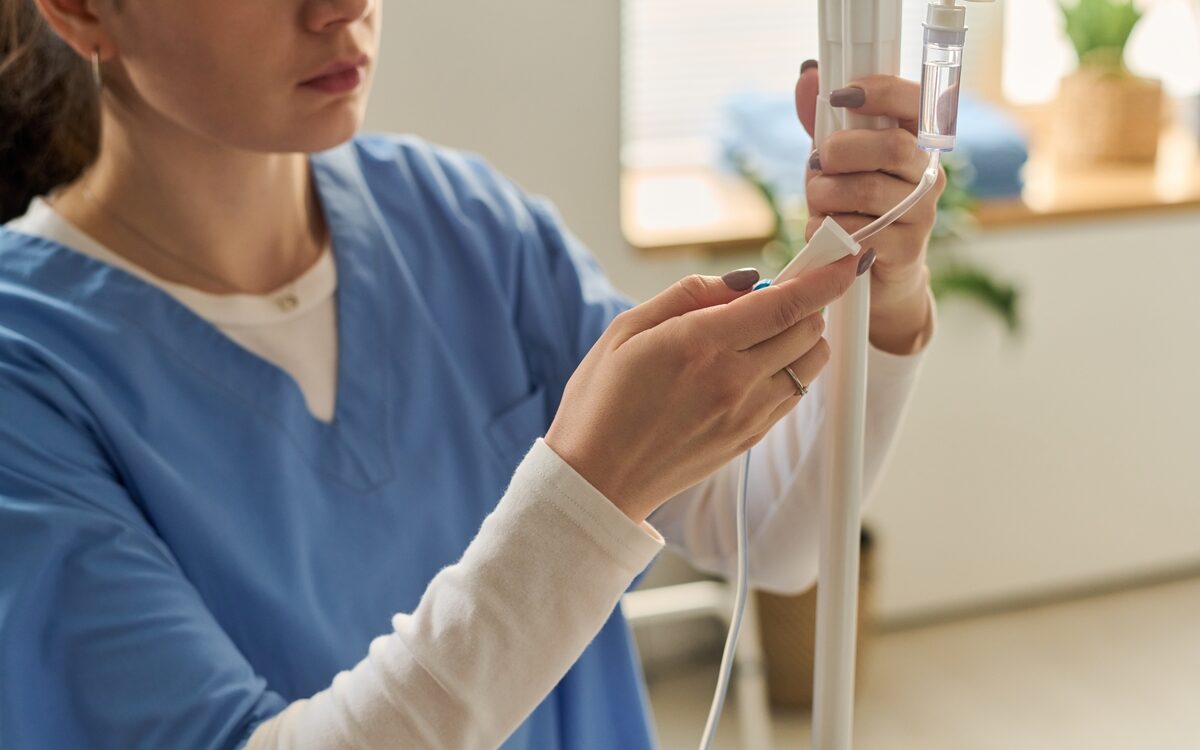 Healthcare professional adjusting IV tubing for an article explaining what’s in an IV drip