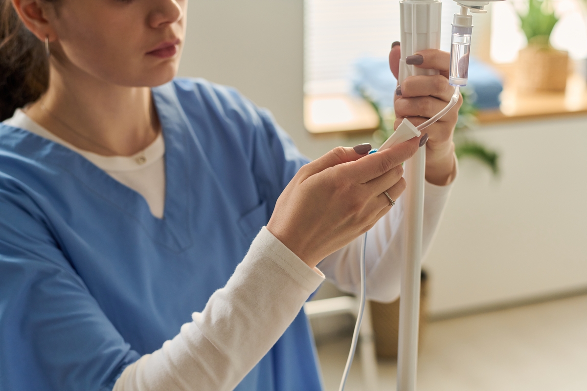 Healthcare professional adjusting IV tubing for an article explaining what’s in an IV drip