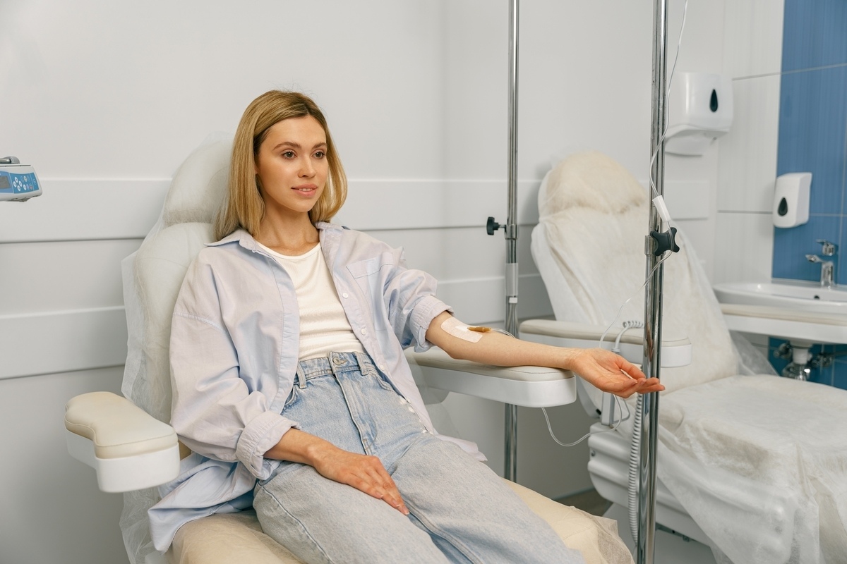 IV hydration for fatigue showing a woman receiving intravenous fluids while resting in a medical clinic.