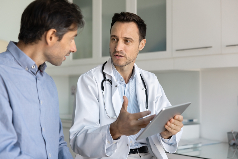 Middle-aged man discussing low testosterone symptoms and testosterone replacement therapy with a healthcare provider.