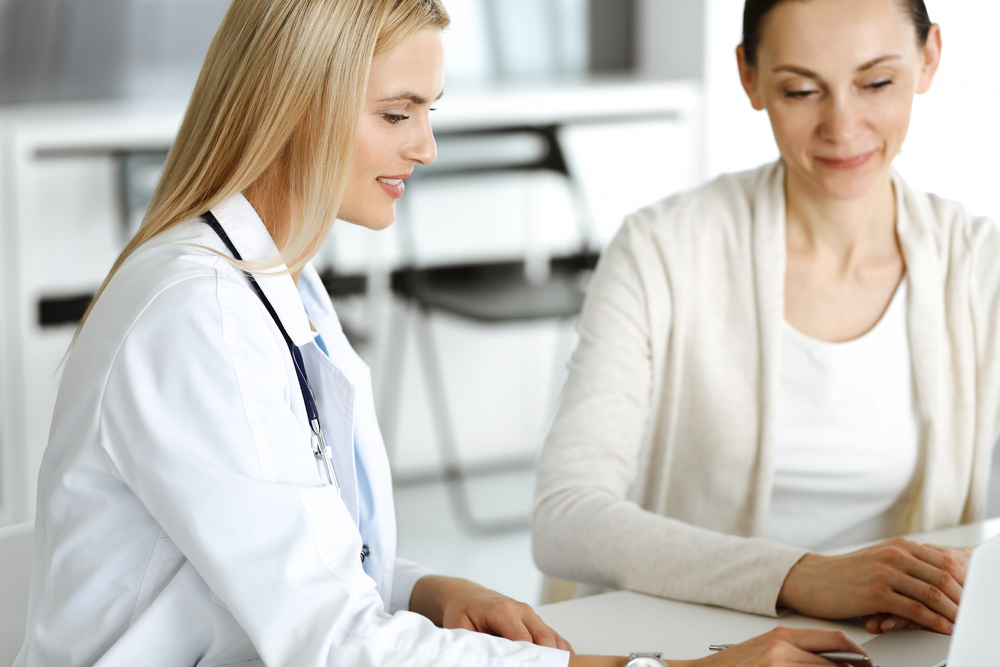 Middle-aged woman discussing menopause symptoms and hormone replacement therapy with a healthcare provider.