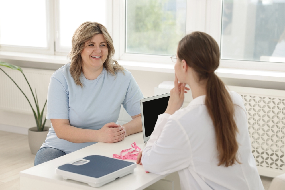 Healthcare provider discussing possible causes of stubborn weight gain and body fat with a patient.
