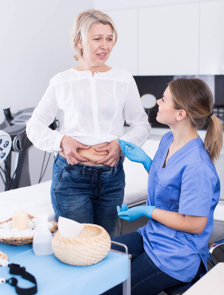 Healthcare provider evaluating stubborn weight gain and body changes during a wellness consultation